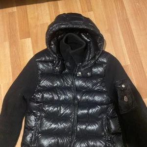 Svart Moncler cardigan - Säljer en moncler cardigan. Storlek L, bra skick. Ända skadan är att knapparna till fickorna fullit av. Öppen för bud