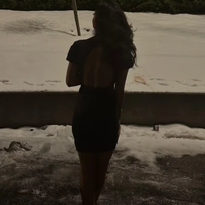 Svart kortklänning med öppen rygg - Supersnygg svart kortklänning med öppen rygg och korta ärmar. 