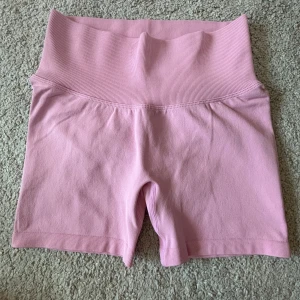 Rosa seamless shorts från Aim'n - Säljer ett par ljusrosa seamless shorts från Aim'n med hög midja och ribbad linning. De är tillverkade i ett stretchigt material som sitter tight och har scrunch-detalj bak. Perfekta för träning eller chill dagar.