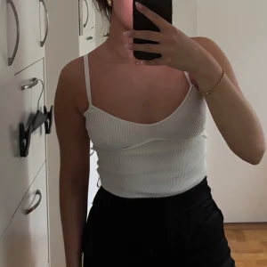 Vit finstickad body - Säljer en vit finstickad linnebody, med ribbad detalj vid bysten. 