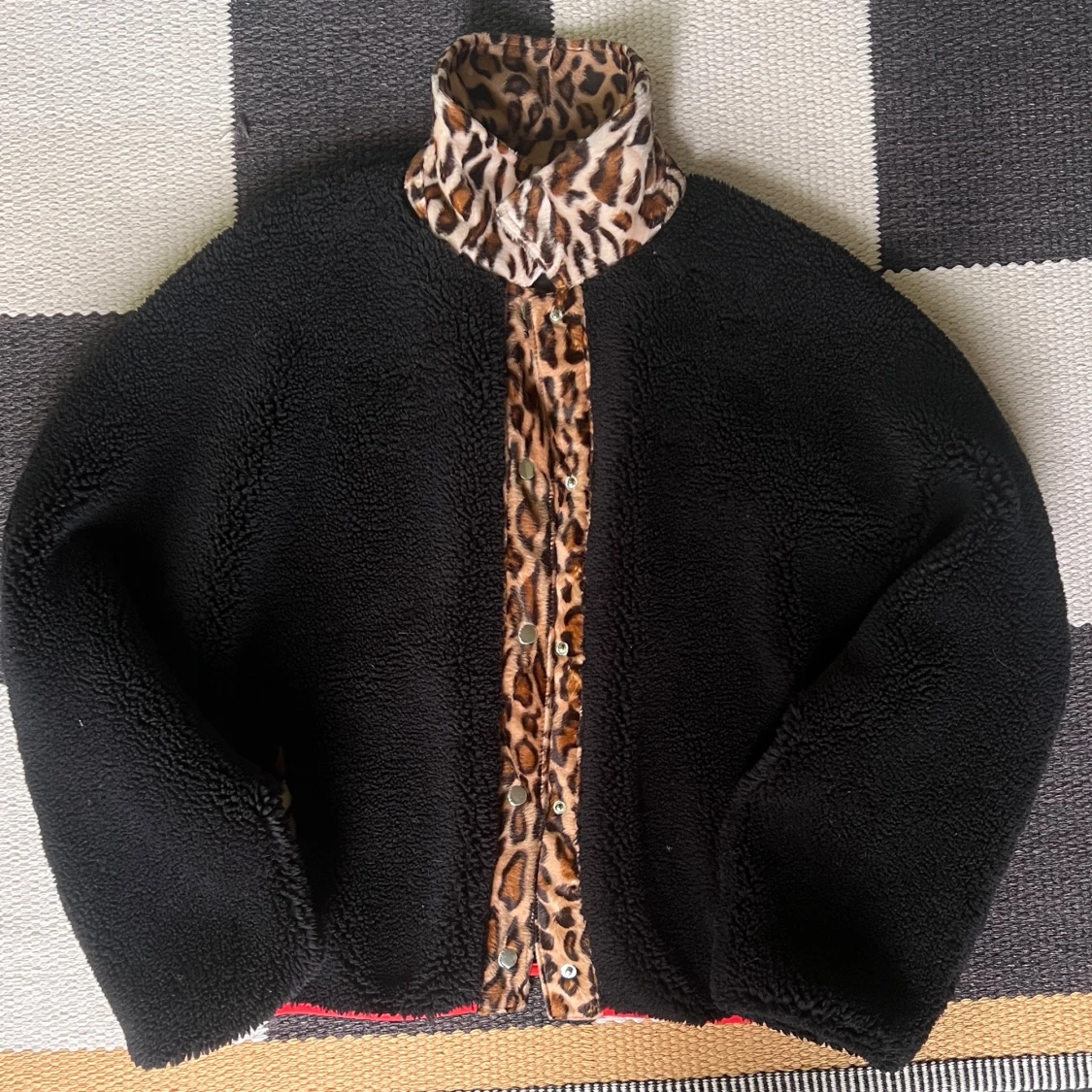 Svart teddyjacka med leopardkrage Stand