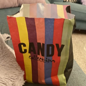 Bjugjbvkkbbvdgjg dg ja wrstidsyesiddhixhfgusurd - Bilderna visar en färgglad godispåse med texten 'CANDY collection' och blandat lösgodis inuti. Ingen bok syns på bilderna.