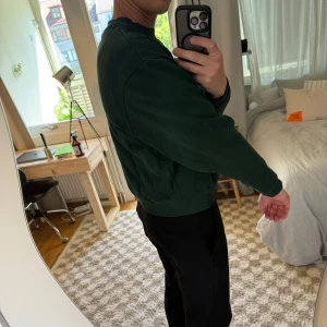 Grön croppad sweatshirt från ASOS Design - Tröjan har rund halsringning, ribbade muddar och är tillverkad i mjuk bomull. Aldrig använd men prislappen är borttagen. Obs. Den är croppad så alltså kortare på längden.