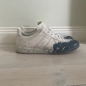 Maison Margiela Skor - Riktigt snygga Maison Margielas som är otroligt trendiga just nu. Skorna är i storlek 43 men passar även 42. Dessa vita gats med blådetalj på tån är ett måste köp denna sommar! Skorna köptes på den amerikanska hemsidan TheRealReal där digital kvitto visas på sista bilden. Nypris på dessa skor är runt 7000kr! Mitt pris är endast 3399kr i och med att skorna inte har någon typ av skada. Man ser på undersulan att de är använda med självklart inget man tänker på. Skriv i dm vid intresse eller frågor😄