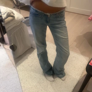 Bootcut jeans no waist nelly  - Säljer ett par ljusblå bootcut jeans från Nelly i storlek 34. Jeansen har låg midja, fransad kant upptill och klassisk femficksdesign. Tillverkade i mjuk denim med dragkedja och knapp framtill. Skriv vid frågor och funderingar!💕