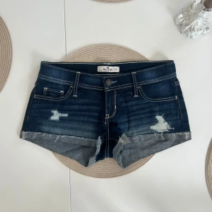 Lågmidjade jeansshorts  - Ett par lågmidjade jeansshorts från Hollister i storlek W25 (XS). Shortsen är i väldigt fint skick. Rakt över midjemått: 37cm. Längd: 19cm. Gren: 18cm. D18