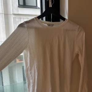 Pyjamas Vit långärmad och långa byxor från Cubus  - Supersöt vit långärmad topp samt långbyxa från Cubus med diskret mönster av små ränder och prickar. Tunn och luftig i bomull, perfekt för vår och sommar. Klassisk rund halsringning och normal passform. Enkel att styla till både jeans och kjol.