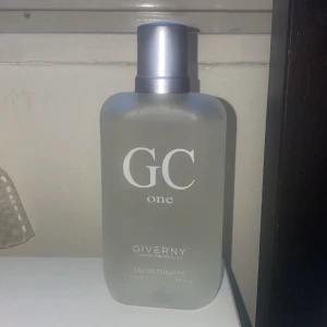 GC One Eau de Toilette 100ml - GC One från Giverny är en fräsch och citrusdoftande eau de toilette i en frostad glasflaska med silverfärgad spraykork. Doften har toppnoter av citron, gröna noter, bergamott, ananas och mandarin, samt blommiga och träiga basnoter.