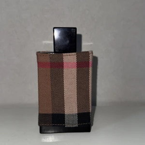 Burberry London Men Eau de Toilette - Burberry London Men Eau de Toilette, en maskulin doft som passar för kommande höst säsong men passar även bra i sommarvädret med dess träiga toner och fräscha ackord. Flaskan har stått några år och har fått macereta och är redo för användning. 100ml flaska med ca 90ml kvar. Håller på att rensa min samling!