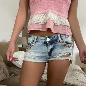 jeans shorts - supersnygga vintage jeans shorts i färgen ljusblå med super coola  färgglada detaljer! Storlek S/36