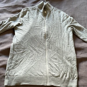 Selected homme fullzip - Säljer en ljusgrå fullzip från selected homme. Den är i storlek S och bra skick förutom ett hål som ni kan se på bild 3 som dock inte syns när man använder den. Hör av er vid frågor