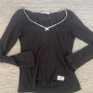Svart långärmad topp från Odd Molly - Säljer en svart långärmad topp från Odd Molly med en söt rosett och v-ringad hals. Den är i storlek 0, motsvarande xs💓