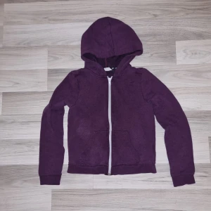 Lila hoodie från H&M - Säljer en mysig lila hoodie från H&M med dragkedja framtill och praktisk huva. Tröjan har långa ärmar och en skön passform, perfekt för kyligare dagar. Den har också dragkedja och fickor framtill för extra bekvämlighet. Perfekt för vardagsbruk!