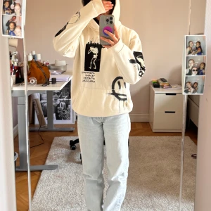 Beige hoodie från FSBN - Säljer en cool beige hoodie från FSBN med tryck i svart och vitt. Hoodien har en avslappnad passform och är perfekt för en casual look. Den har en stor huva och tryck både fram och bak som ger en unik stil.