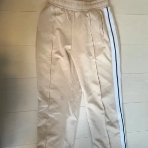 Palm Angels Pants🌟 - Fräscha beige byxor från Palm Angels med vita och svarta ränder längs sidorna. Väldigt bekväma. Perfekta för en avslappnad stil. Kan gå ner i pris vid snabb affär!
