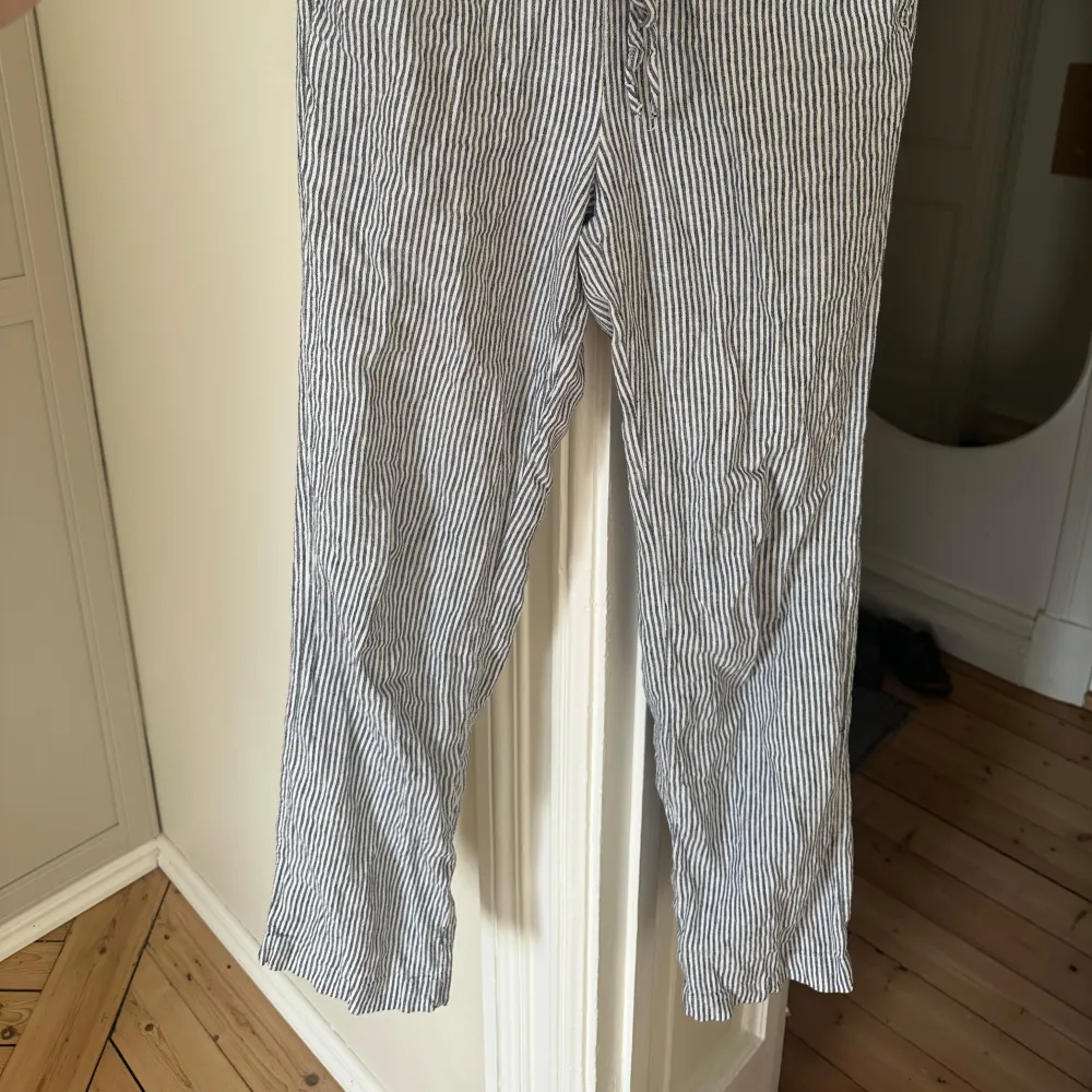 Säljer ett par randiga byxor från BikBok i storlek XS. Byxorna har en bekväm passform med snörning i midjan och är perfekta för en avslappnad stil. De är tillverkade i ett lätt och luftigt material. Passar mig som är S. Super sköna under sommaren men inte min stil längre. Farkut & Housut.