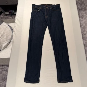Nudie Jeans - Säljer ett par mörkblå jeans från Nudie i storlek 34/34. Modellen heter Lean Dean Dry 16 Dips och har ett nypris på 1400kr. De har en slim passform och är tillverkade i högkvalitativt denim. Jeansen är använda ett fåtal gånger och är i helt nyskick. Skriv gärna om du har frågor 😊
