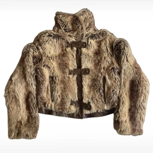 Brun pälsjacka med knappar - Säljer en snygg brun pälsjacka med knappar framtill. Jackan har en hög krage och långa ärmar. En liten reva på insidan men det är inget som stör!