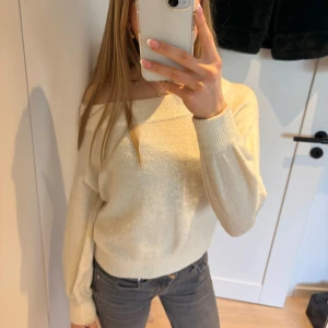 Vit stickad tröja - En snygg vit stickad tröja som är offshoulder. Säljer då den bara är använd fåtal gånger. Meddela vid frågor eller bilder