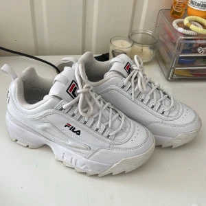 Vita sneakers från Fila - Snygga vita sneakers från Fila med en chunky sula och klassisk snörning. Skorna har Fila-loggan på sidan och tungan, vilket ger en sportig look. Perfekta för en casual stil. Dem är använda ca 3 gånger. Priset kan diskuteras vid snabb affär 