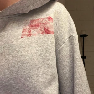 Grå hoodie med rött mönster - Säljer en grå hoodie med ett unikt rött mönster på bröstet och ryggen. Perfekt för en avslappnad stil. Hoodien har en klassisk passform med långa ärmar och en bekväm huva. Denna bild är ganska suddig på trycket men kommer såklart göra nya.