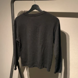 Svart långärmad tröja - Säljer en stilren svart långärmad tröja. Perfekt för kyligare dagar och enkel att matcha med olika outfits. Tröjan har en klassisk passform och är tillverkad i ett mjukt material.