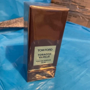 Tom Ford Tobacco Vanille Eau de Parfum 30 ml - Lyxig parfym från Tom Ford med en rik doft av tobak och vanilj. Flaskan rymmer 30 ml och kommer i en elegant brun förpackning med guldiga detaljer. Perfekt för den som vill ha en sofistikerad och varm doftupplevelse.