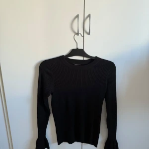 Svart ribbad tröja ifrån lindex - Säljer en stilren svart ribbad tröja med långa ärmar. Perfekt för en enkel och elegant look. Passar till många olika outfits och tillfällen.