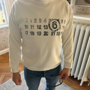 Maison margiela tröja - Säljer en snygg vit tröja från maison margiela i storlek M. Den är som i nyskick och köpte den i november. Den är jättefint omhändertagen!!! Den har samma passform som den svarta jag har lagt upp!! Modellen är 180