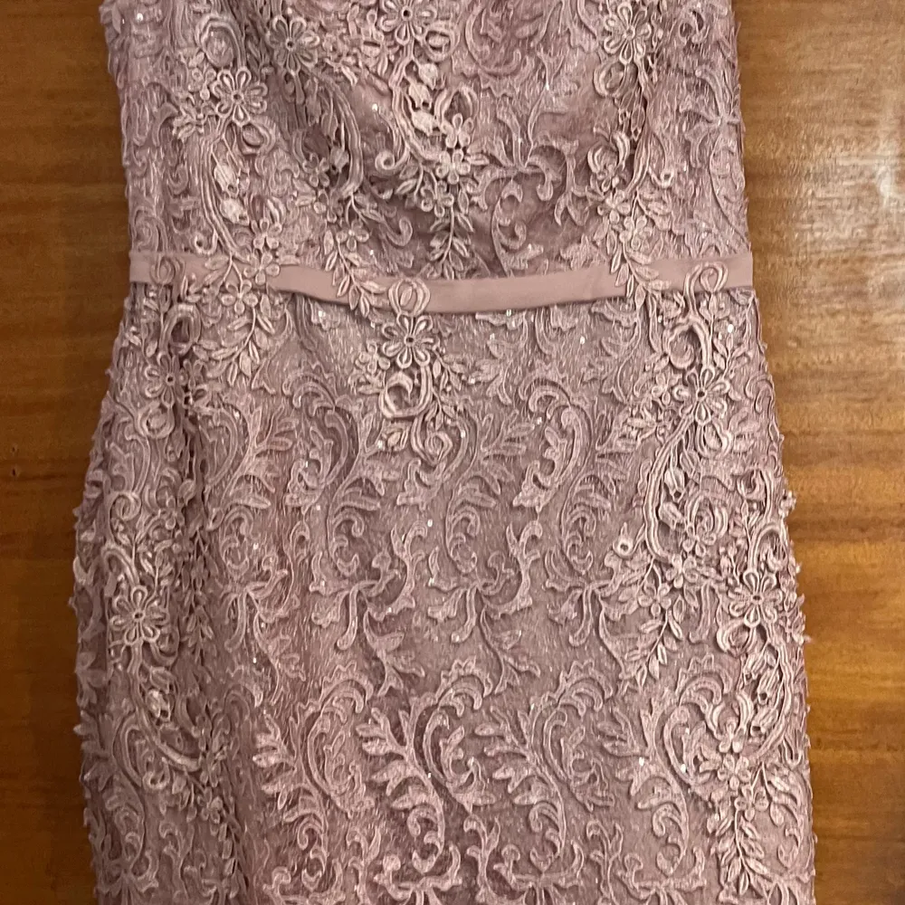 Elegant rosa klänning med vacker spetsdetaljering och offshoulder-design. Perfekt för speciella tillfällen med sin feminina och stilrena look.. Mekot.