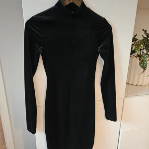 Velourklänning H&M - Oanvänd svart, figurnära plysch/velourklänning från H&M.