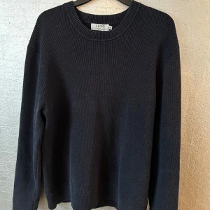 Svart ribbad tröja från Lululemon - Säljer en stilren svart ribbad tröja från Ljung. Tröjan har en klassisk rund halsringning och långa ärmar, perfekt för en avslappnad look. Tröjan är XL men den är liten o storleken o passar L