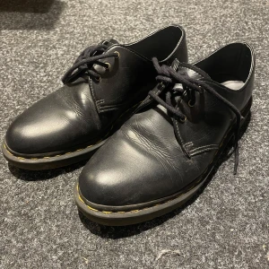 Dr. Martens svarta  - Tydliga täcken på användning både på sulan och på lädret. 