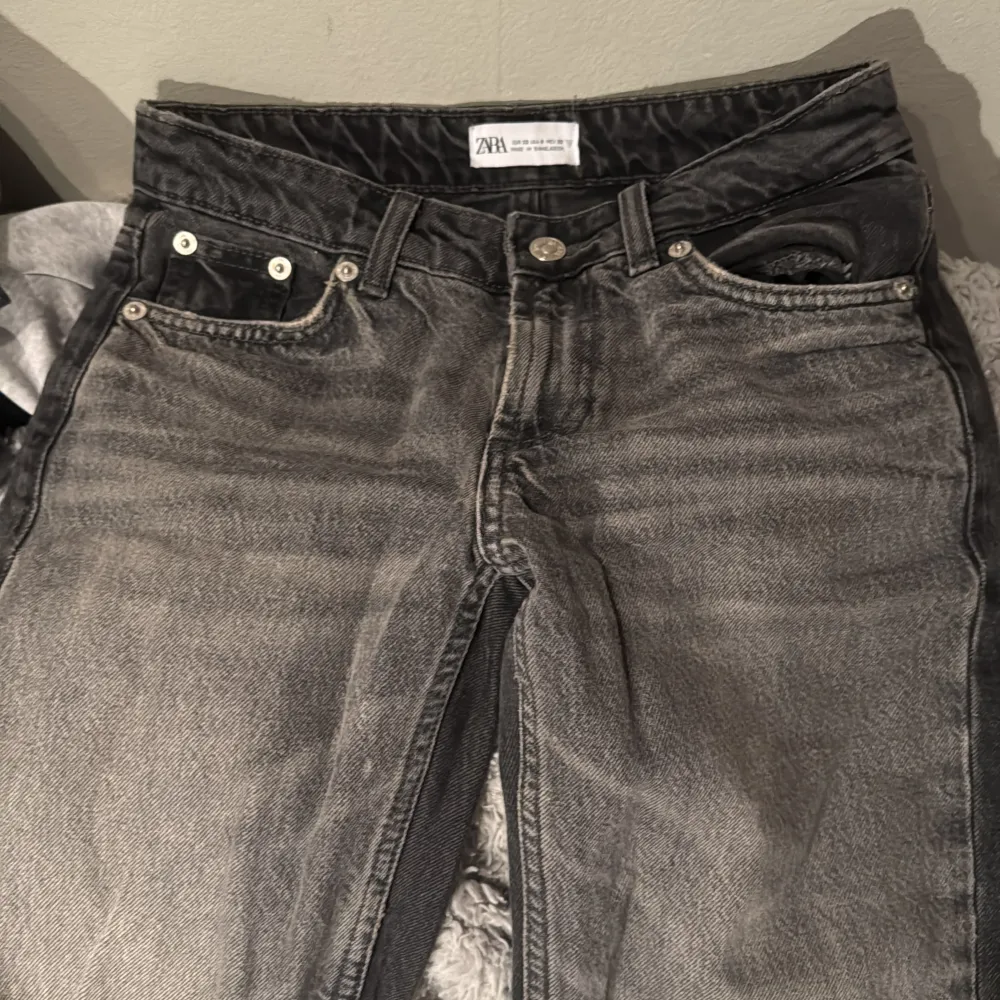  grå jeans från Zara med en klassisk femficksdesign. De har en knappgylf och är tillverkade i ett slitstarkt denimtyg. Perfekta för en avslappnad stil. har inte använt dom för dom var väldigt för stora mesta dels för långa. men dom är lite ljusare på framsidan å lite men mörka och svarta på baksidan. Farkut & Housut.