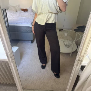 Gråa vida byxor från Bershka - Snygga gråa byxor från Bershka i storlek 38. De har en rak och vid passform med hög midja och bälteshällor. Perfekta för en clean och stilren look, passar till både sneakers och boots.