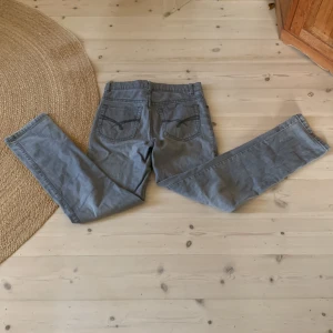 Flash jeans - Säljer ett par gråa flash jeans med raka ben och klassiska bakfickor.Jeansenär i ett mjuk material och har en enkel, stilren look som passar till det mesta. Perfekta för dig som gillar en clean och avslappnad stil.