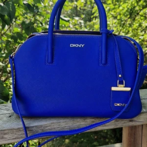 Blå handväska från DKNY - Snygg blå handväska från DKNY med flera fack inut.