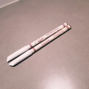 Oriflame Nail White Pencil duo - Två vita manikyrpennor från Oriflame, perfekta för att markera nagelkanter och skapa en fräsch fransk manikyr-look. Pennorna är vita med röda detaljer och har en klassisk pennform som är enkel att använda för snygga naglar.  Båda är oanvända