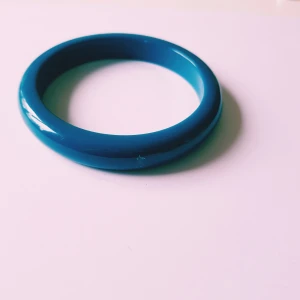 Blått chunky armband i plast - Coolt blått armband med chunky och rund form. Armbandet är helt slätt och har en glansig finish som ger en modern vibe. Perfekt för att addera färg till din outfit.  Helt & fint skick