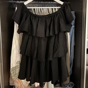 Svart volangklänning offshoulder - Supersnygg svart kortklänning med flera volanger och offshoulder-modell. Funkar även som en offshoulder topp!!💗