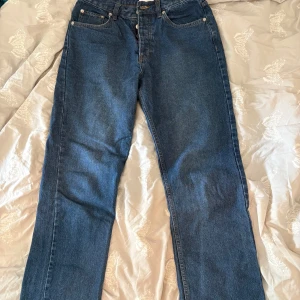 Studio Total loose fit jeans blå - Säljer ett par blå loose fit jeans från Studio Total. Jeansen är tillverkade i 100% bomull och har en klassisk femficksdesign med raka ben och normal midja. Perfekta för dig som gillar en avslappnad och trendig look.