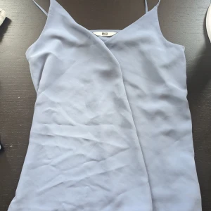 Ljusblå linnetopp med smala axelband - Säljer en ljusblå linnetopp med smala axelband och v-ringning. Perfekt för varma dagar och enkel att matcha med olika outfits.❤️