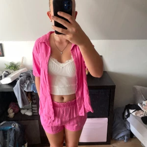 Rosa shorts och skjorta från SHEIN Teen - Säljer ett par rosa shorts och skjorta från SHEIN Teen i storlek 146. De har en loose passform, elastisk midja och är tillverkade i ett svalt linnematerial. Perfekta för sommardagar när du vill ha något bekvämt och färgglatt.