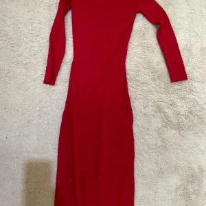 Röd ribbad långklänning från H&M - Snygg röd långklänning från H&M i ribbat material. Klänningen har lång ärm, figurnära passform och en slits på sidan som ger extra edge. Perfekt för dig som gillar en enkel men ändå statement look. Aldrig änvänd säljer då jag inte behöver den, storlek 158 men passar även längre 
