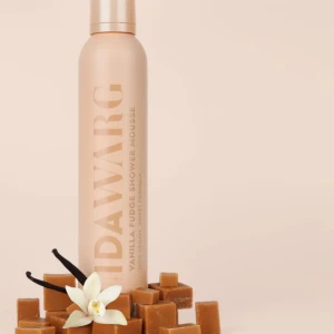 IDAWARG Vanilla Fudge Shower Mousse - En lyxig duschmousse med doft av vaniljfudge från IDAWARG. Kommer i en beige metallflaska med guldig text. Moussen är vegansk och har en söt, krämig formula som gör duschen extra härlig.