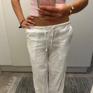 Vita linnebyxor från Gina Tricot - Snygga och luftiga vita linnebyxor från Gina Tricot med dragsko i midjan och sidfickor. Perfekta för varma dagar och riktigt sköna att ha på sig. Byxorna har en avslappnad passform och är tillverkade i mjukt linne.