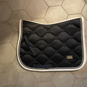 Equestrian Stockholm schabrak  - Snyggt hoppschabrak i mörkblå färg från equestrian Stockholm. Endast använt 3 ggr. Nypris: 899kr