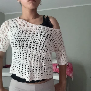 Vit virkad blus med halvärm - Superfin vit virkad blus med halvärmar och croppad passform. Den har ett luftigt, genombrutet mönster och en avslappnad offshoulder-look. Perfekt att styla över ett linne eller bikini. Ger en chill och somrig vibe!