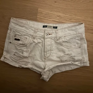 Vita slitna jeansshorts - Säljer ett par supersnygga vita jeansshorts ifrån pull&bear som inte går att köpa längre. 