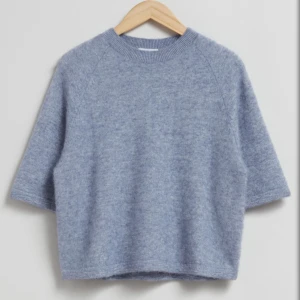 Ljusblå stickad tröja & Other Stories - Supermjuk ljusblå stickad tröja från & Other Stories. Tröjan har en boxig passform, rund halsringning och halvlånga ärmar. Perfekt för lager-på-lager och chill vibes. Materialet är fluffigt och känns riktigt cozy.